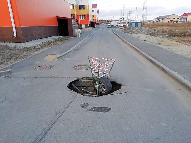 В Ноябрьске легковушка провалилась в яму на дороге в новом микрорайоне. ФОТО