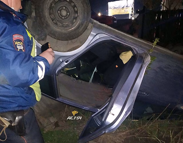 Автомобиль снес забор и перевернулся на крышу в Новосибирске