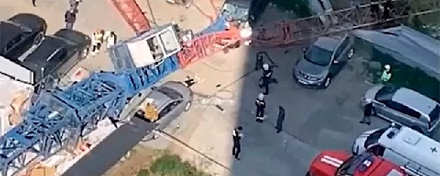 В Новосибирске строительный кран с рабочим внутри рухнул на автомобили — Видео