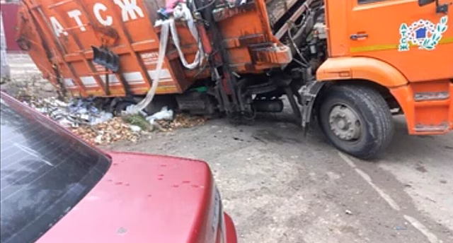 Мусоровоз в Саратове провалился в дорожную яму у контейнеров