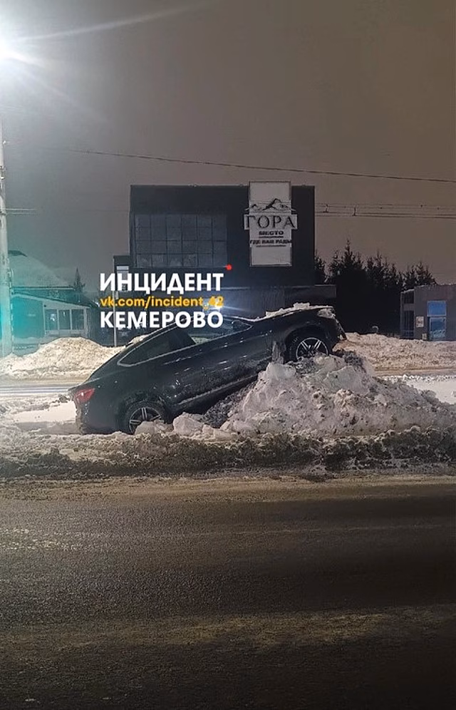 Автомобиль "взобрался" на снежную гору в Кемерове